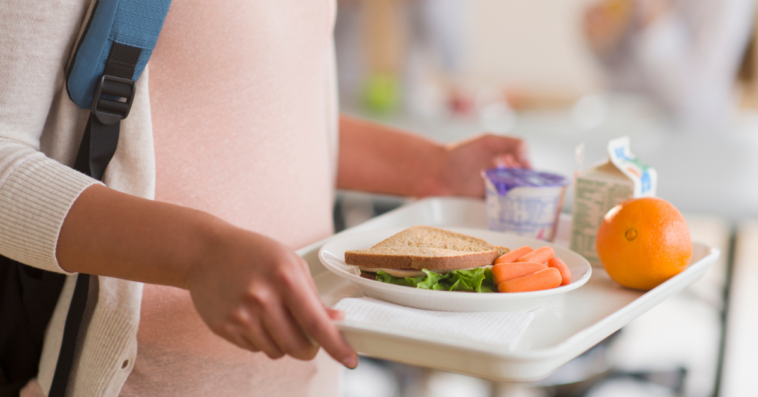 Girl holding a tray in cafeteria