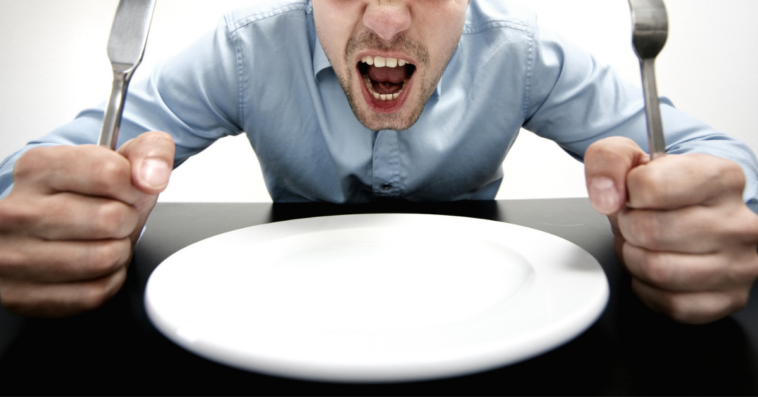 Angry and hungry man with empty plate