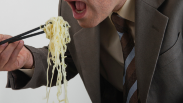 Man eating noodles with chopsticks