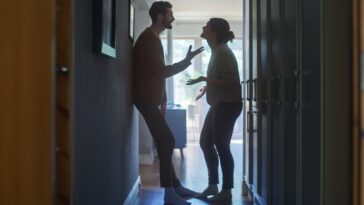 Young Couple Arguing and Fighting in a Dark Claustrophobic Hallway of an Apartment.