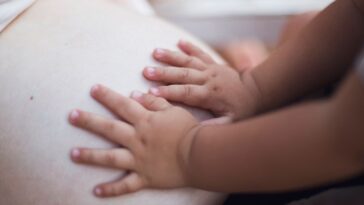 Baby hands on pregnant belly