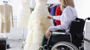 woman in wheelchair looks at wedding dress
