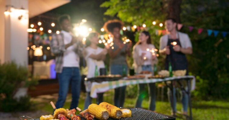 Blurred photo of a happy group of friends enjoying a barbecue party together in backyard.