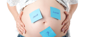 pregnant person with names on notes on their belly