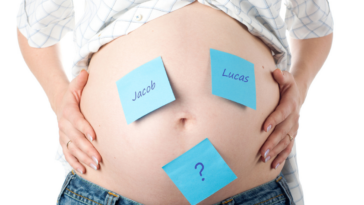 pregnant person with names on notes on their belly