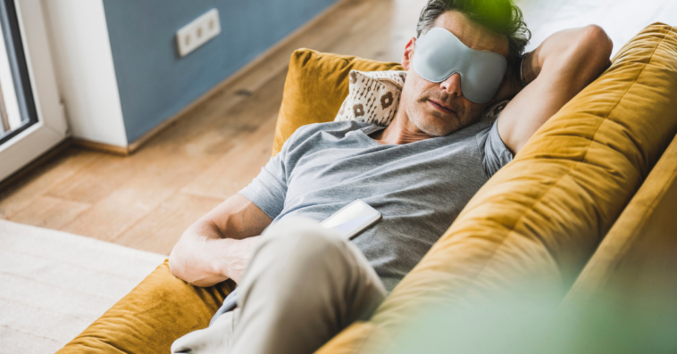 man napping with eye mask