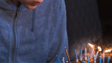 teen boy blowing out birthday candles