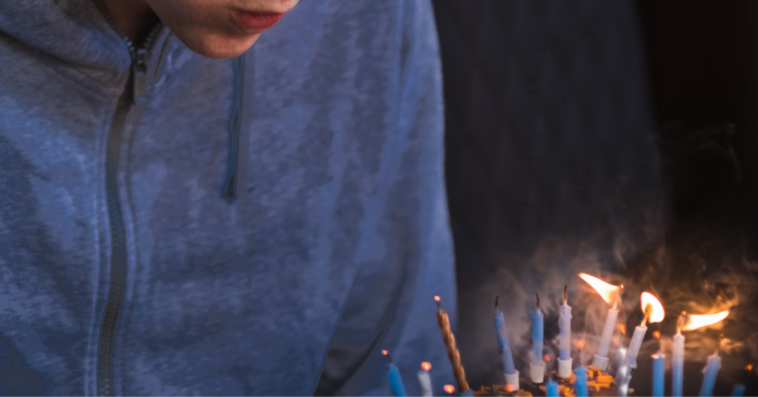 teen boy blowing out birthday candles
