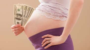 Pregnant woman holding cash