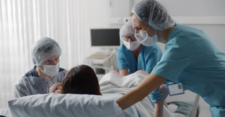 Laboring woman surrounded by medical team