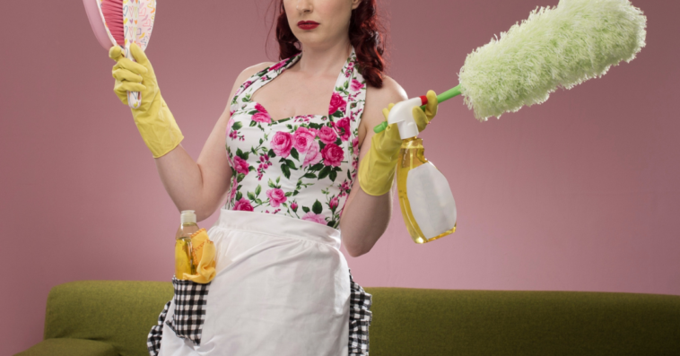 Woman cleaning her home while wearing an apron