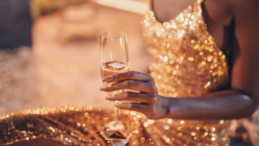 seated woman in gold dress with champagne