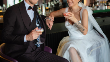 groom and bride sitting at a bar with cocktails