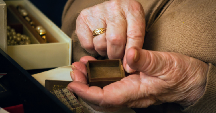 older person sorts through jewelry