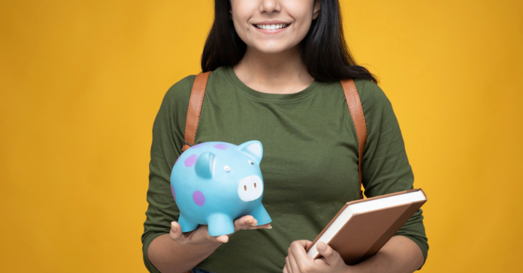 College student holding supplies and a piggy bank