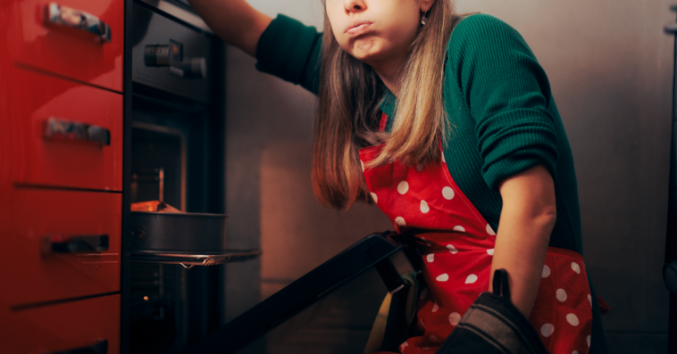 A frustrated woman in front of an oven.