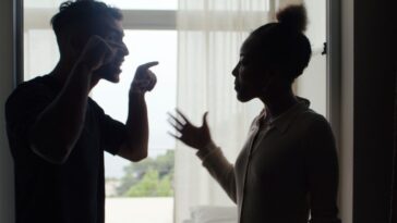 Unhappy couple fighting and gesturing in the living room. Stock photo