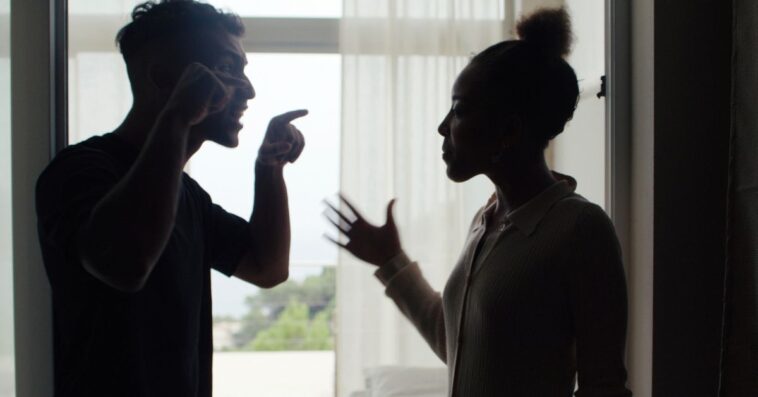 Unhappy couple fighting and gesturing in the living room. Stock photo
