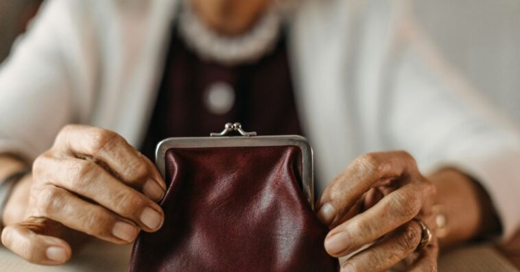 Older woman counting coins from her wallet