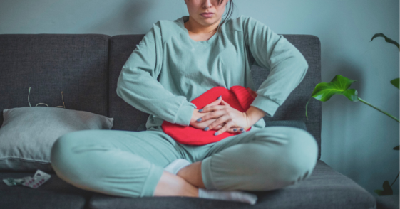 Woman pressing a hot pad to her stomach
