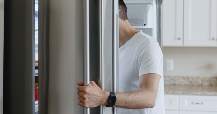 A man looking into a refrigerator.
