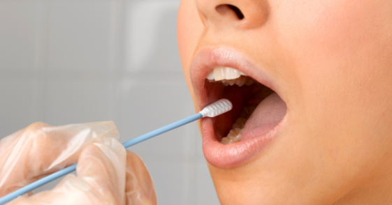 A woman getting a cotton swab inserted into her mouth.
