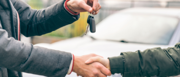 people shaking hands and exchanging car keys
