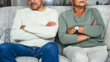 upset older couple seated on couch