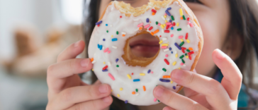 child holding donut with bite in it