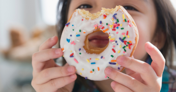 child holding donut with bite in it