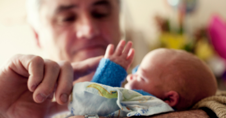 grandfather holding newborn grandchild