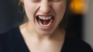 A young woman angrily screaming.