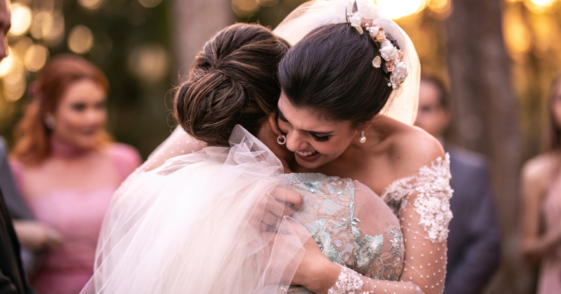 A bride hugging another woman.