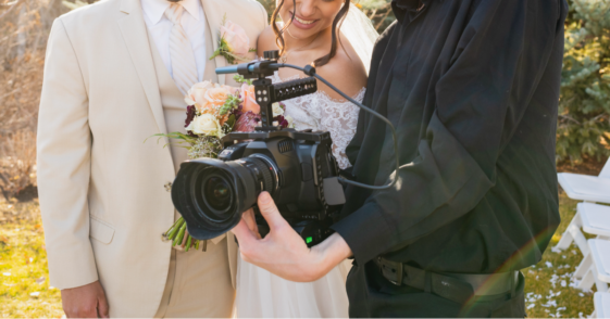 A bride and groom looking at pictures on a digital camera.