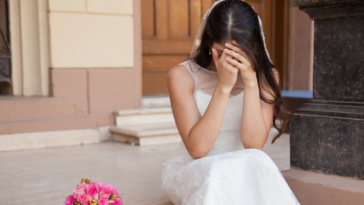 A bride crying on stairs.