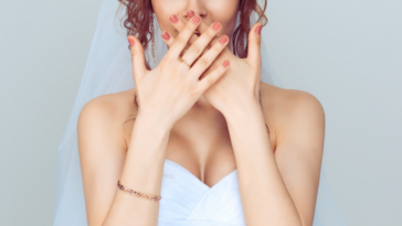 Bride covering her mouth with her hands.