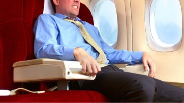 Man has a fear of flying. He sits grasping the chair.