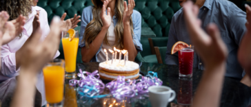 Woman celebrating birthday with dinner at restaurant