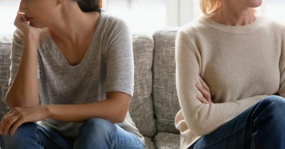 arguing mother and daughter seated on couch