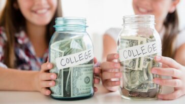 Twin sisters hold out two jars with money in them labeled College.