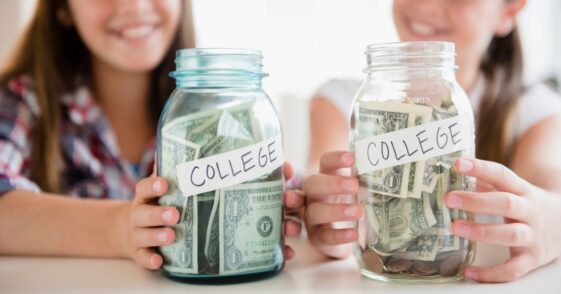 Twin sisters hold out two jars with money in them labeled College.