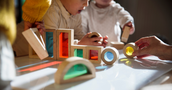 Children playing at a table playing with blocks.