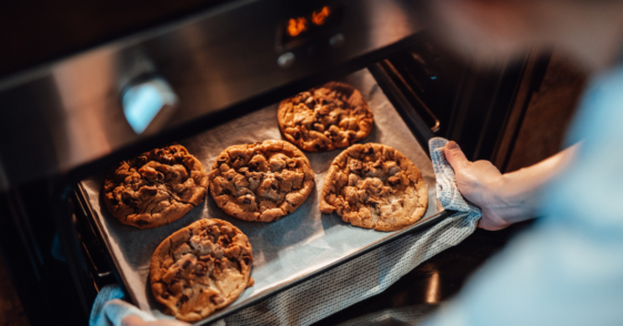 A tray of cookies being taken out of the oven.