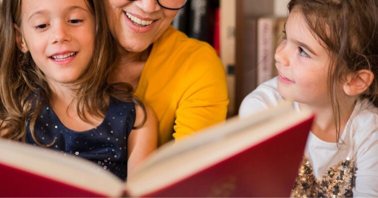 Happy older woman reading tales for her two beautiful granddaughters.