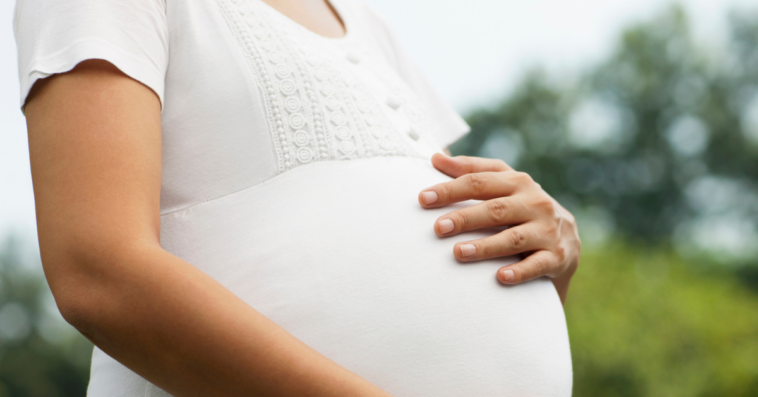 pregnant person with their hand on their belly