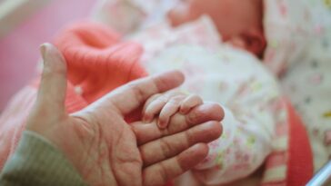 Newborn baby holding onto mother's hand