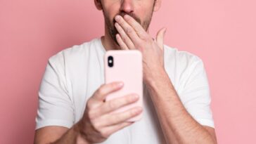 Surprised man looking at smartphone