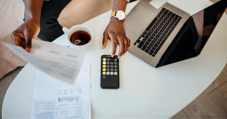 A man going over his finances on a table with a calculator.