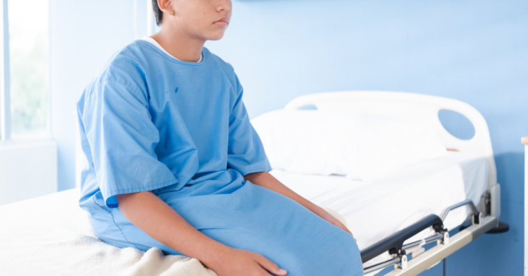 young person seated on hospital bed