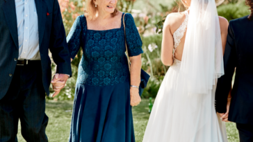 A bride and groom looking at an older couple.